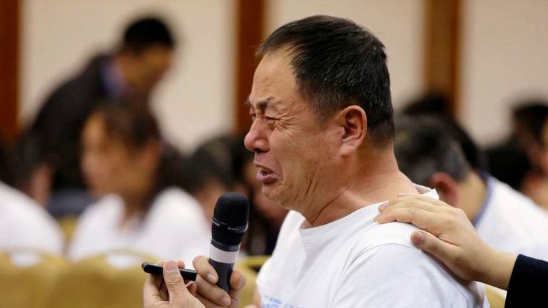 A father whose son was aboard Malaysia Airlines flight MH370, cries as he asks a question during a briefing