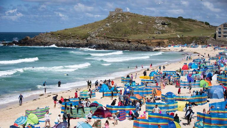 Holidaymakers enjoy the fine sunny weather at Porthmeor Beach in St Ives