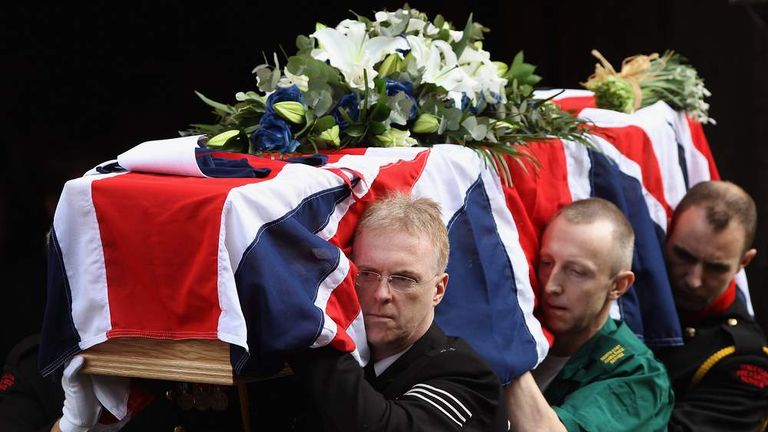 Emergency service workers carry the coffin of PC David Rathband