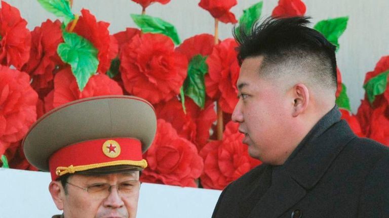 North Korean leader Kim Jong-un, flanked by his uncle North Korean politician Jang Song-thaek, leaves a military parade in Pyongyang