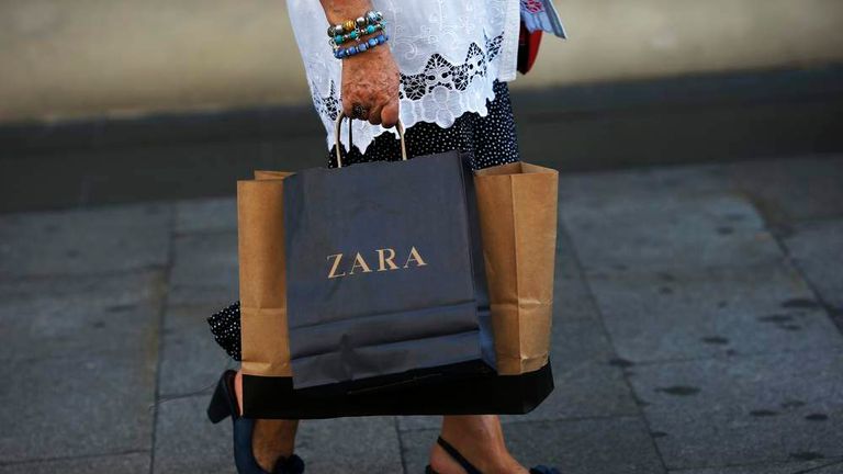 A woman walks with a Zara bag in hand in Madrid