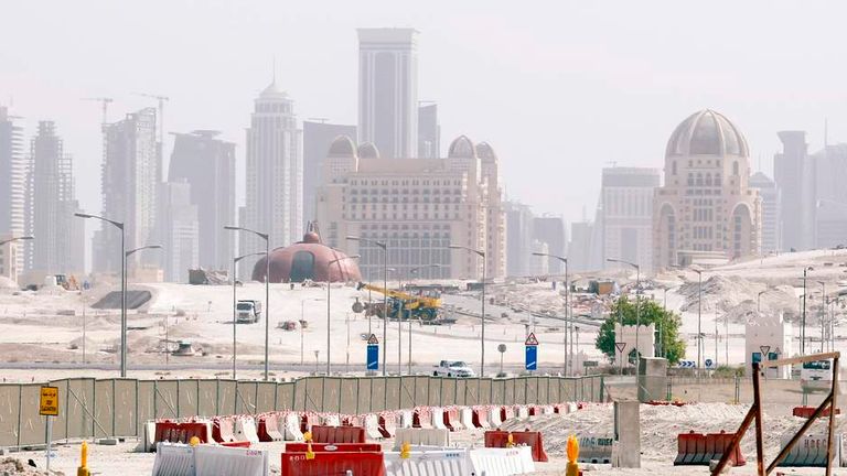 Construction cranes and bulldozers operate at a real estate construction site being built by Qatar's Lucille properties in Doha