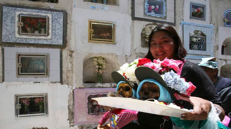 A woman carries decorated skulls during a 'Day of the Skulls' ceremony
