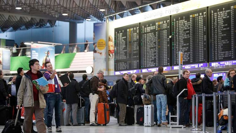 People queue at the departure area of the Fraport airport in Frankfurt