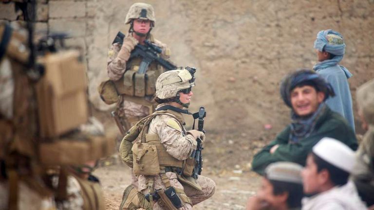 DOD handout photo of Lance Cpl. Sienna De Santis and U.S. Navy Petty Officer 3rd Class Heidi Dean greeting children during a patrol in Sangin Valley