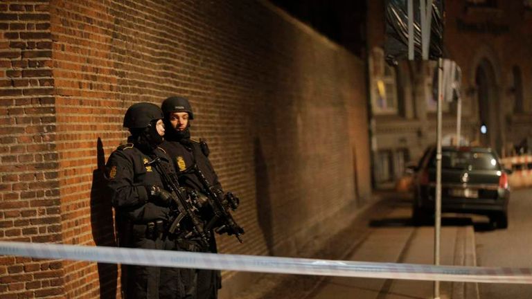 Policemen are seen along a street in central Copenhagen