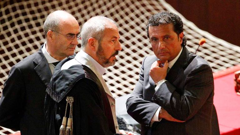 Schettino, captain of the Costa Concordia cruise ship, talks with his lawyers during a trial in Grosseto