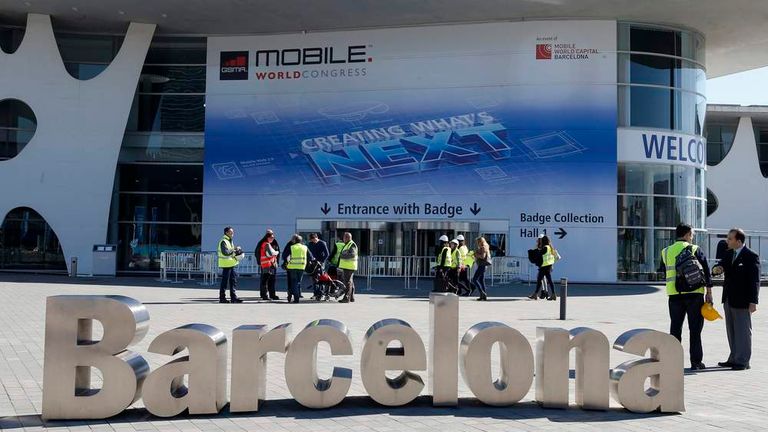 Workers walk past a Mobile World Congress entrance in Barcelona