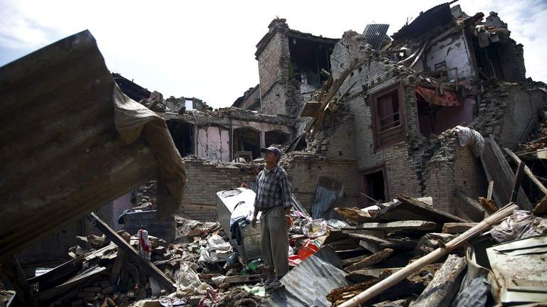 A man stands on the debris of collapsed houses after a fresh 7.3-magnitude earthquake struck Nepal, in Sankhu