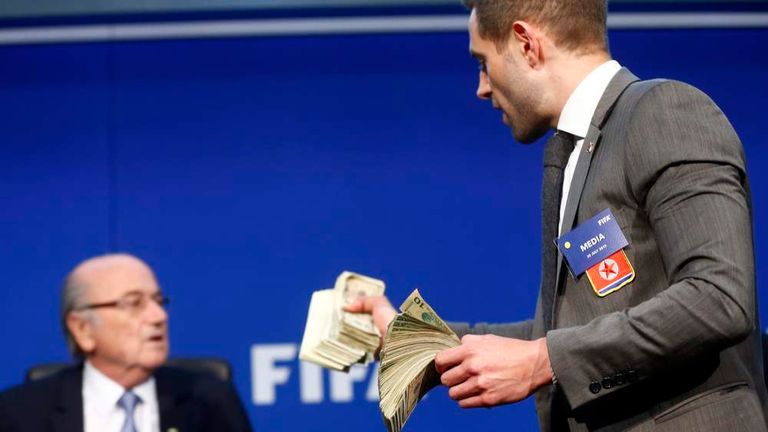 British comedian Simon Brodkin known as Lee Nelson holds banknotes in front of FIFA President Blatter at a news conference after the Extraordinary FIFA Executive Committee Meeting at the FIFA headquarters in Zurich