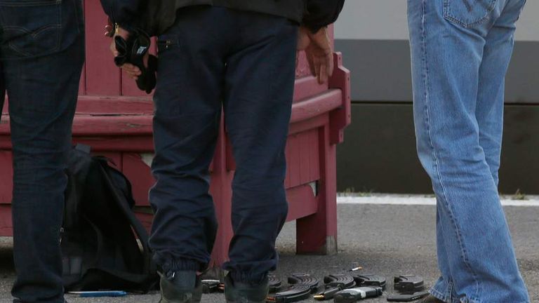 French judicial police stand on the train platform near weapon cartridges and a backpack in Arras after shots were fired on a Thalys high-speed train