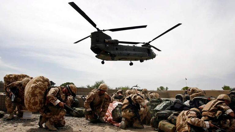 British soldiers take cover as a helicopter lands at Musa Qala in Helmand province