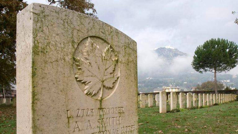 Rebuilt abbey of Monte Cassino is seen behind the grave of a Canadian soldier in Cassino