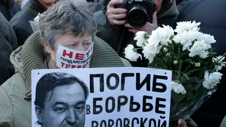 A woman holds a placard with a portrait of Sergei Magnitsky during an unauthorised rally in central Moscow