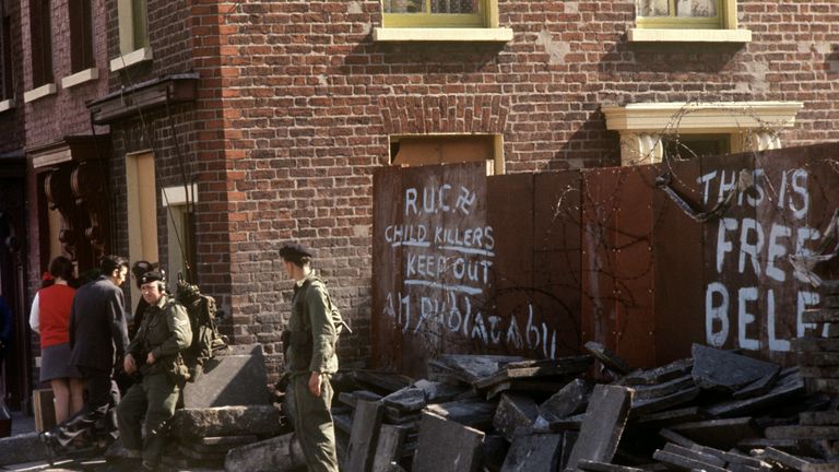 Slogans, soldiers and debris in Falls Road, Belfast.