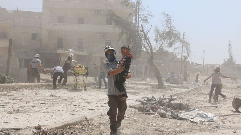 A Syrian rescuer carries a child in the Maadi district of eastern Aleppo after a barrel bomb attack