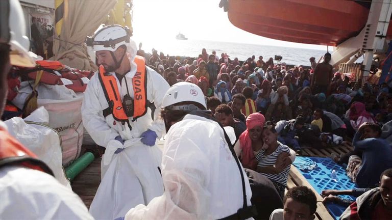 Italian coastguard transfer the body of a migrant onto their boat