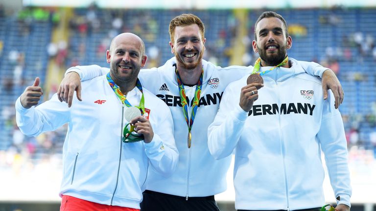 Silver medallist Piotr Malachowski of Poland (left)