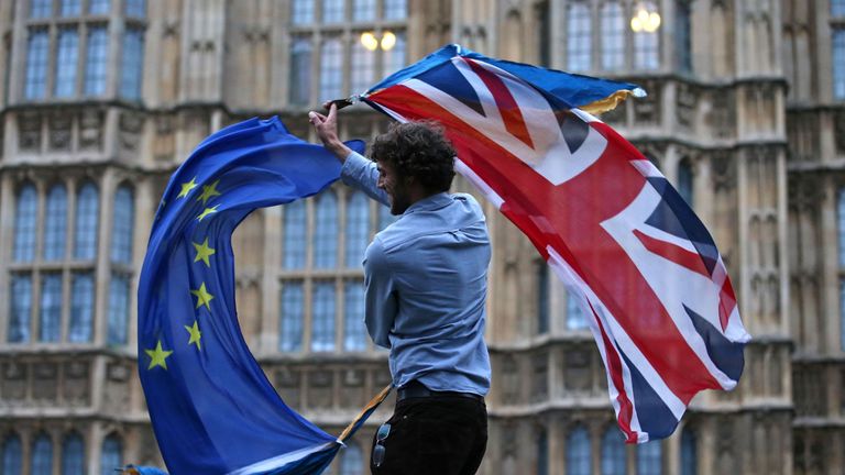 A man waves both a Union flag and a European flag together on College Green outside The Houses of Parliament at an anti-Brexit protest in central London