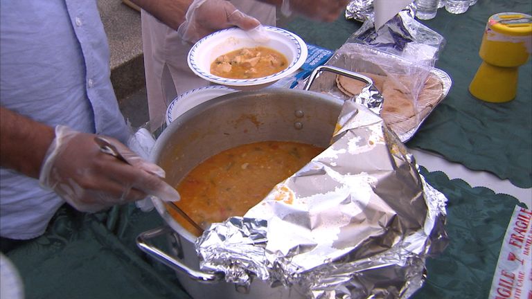 Man dishes out food at a soup kitchen for the homeless