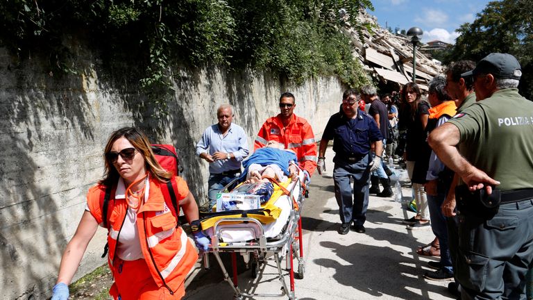 An injured person is carried away on a stretcher following an earthquake at Pescara del Tront