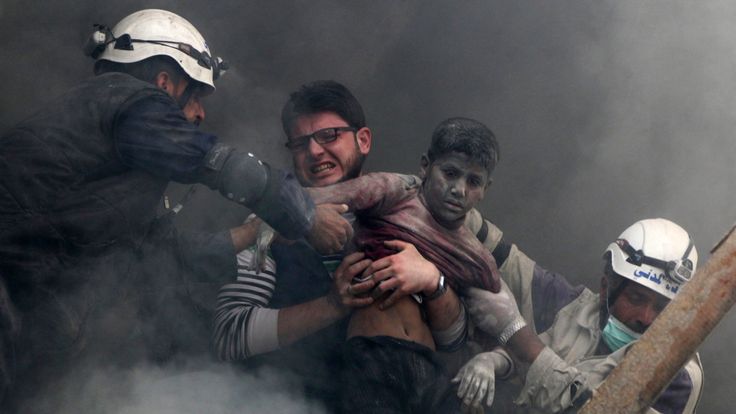A boy is pulled from rubble after an alleged barrel bomb strike in al Shaar, Aleppo