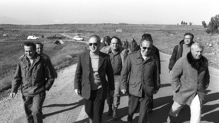 Israel&#39;s Prime Minister Yitzhak Rabin (2nd L), Defence Minister Shimon Peres and Security Advisor Ariel Sharon (R) walk together during a visit to an army base in the Golan Heights on December 11, 1975 