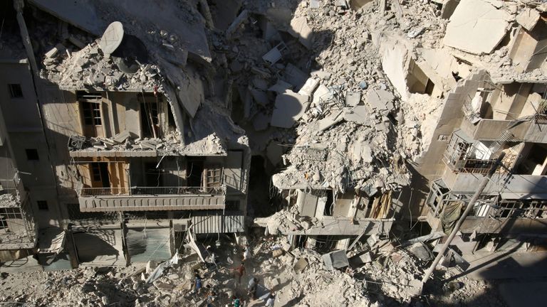 People dig in the rubble in an ongoing search for survivors at a site hit previously by an airstrike in rebel-held Tariq al-Bab in Aleppo, Syria
