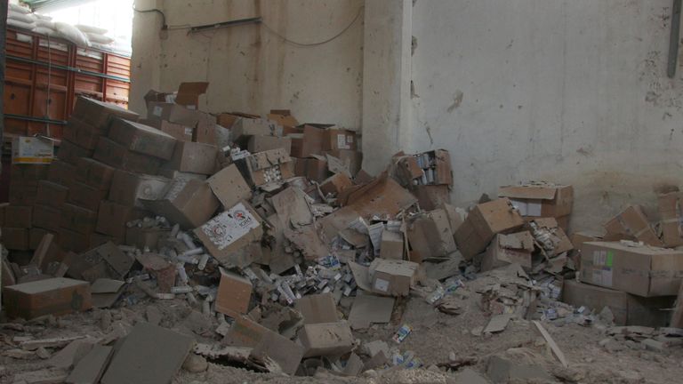 Damaged Red Cross and Red Crescent medical supplies lie inside a warehouse after an airstrike