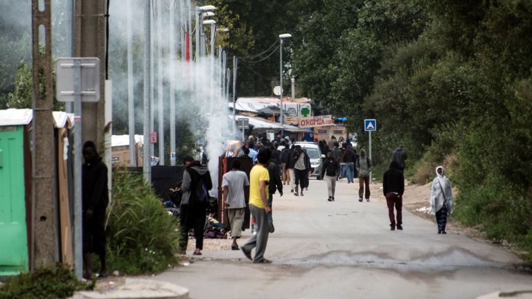 Migrants walk on September 26, 2016 in the so-called &#39;Jungle&#39; migrant camp in the French northern port city of Calais. French President Francois Hollande said on a visit to the port of Calais on September 26, 2016 that the sprawling &#39;Jungle&#39; migrant camp would be &#39;definitively dismantled&#39; under a plan to relocate the migrants to centres around the country. 