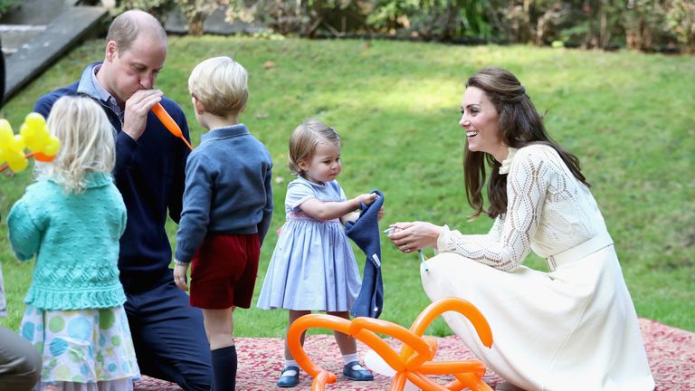William blows up a balloon for George as Kate watches on