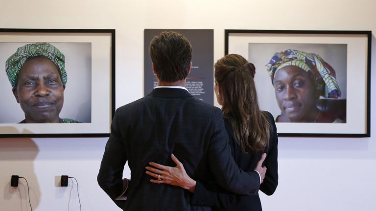 Jolie and Pitt looking at pictures of victims of violence during the Global Summit to End Sexual Violence in Conflict in London in 2014
