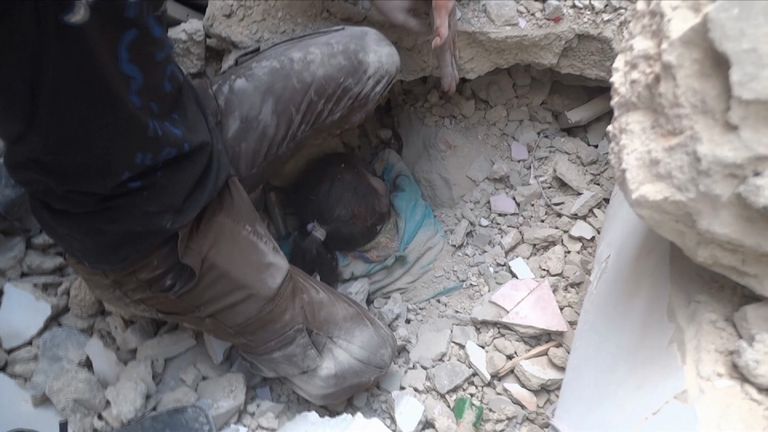 A young Syrian girl trapped in the rubble of a building in Aleppo