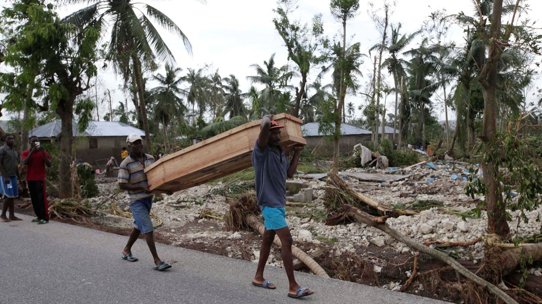 Men carry a coffin after Hurricane Matthew hit Cavaillon, Haiti