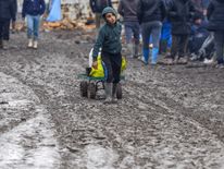 A young migrant pulls a trolley in a muddy field at a camp of makeshift shelters for migrants and asylum-seekers from Iraq, Kurdistan, Iran and Syria, called the Grande Synthe jungle, near Calais, France, February 3, 2016. European Union countries on Wednesday approved a 3 billion euro ($3.32 billion) fund for Turkey to improve living conditions for refugees there in exchange for Ankara ensuring fewer of them migrate on to Europe. REUTERS/Yves Herman