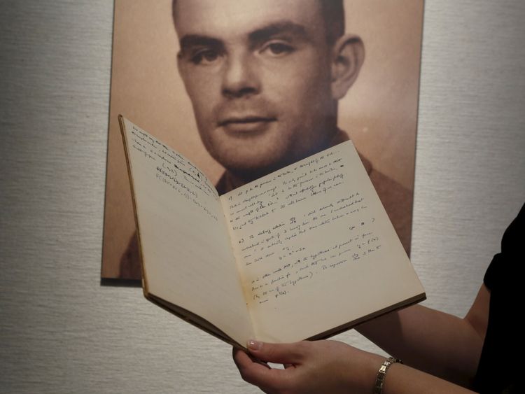 A notebook of British mathematician and pioneer in computer science Alan Turing is displayed in front of a photo of him during an auction preview in Hong Kong March 19, 2015. The notebook about mathematics and computer science written by Nazi-code breaker Turing will be sold at an auction, Bonhams auction house said in January. The 56-page manuscript is expected to fetch at least seven figures, with a portion of the proceeds going to charity, when it goes up for sale on April 13 in New York. REU