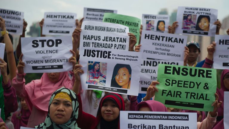Indonesian migrant workers hold up placards of slain colleagues Seneng Mujiasih and Sumarti Ningsih