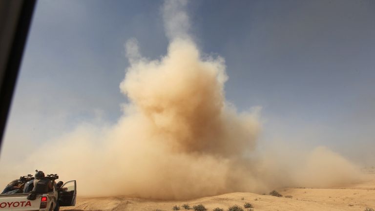 Smoke rises from a bomb taken through the window of a military vehicle in Qayyarah 