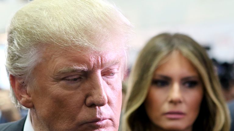 Donald Trump speaks to the media as wife Melania looks on during the Presidential Debate at Hofstra University on September 26, 2016