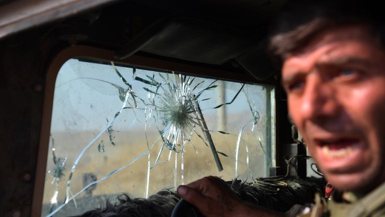 MOSUL, IRAQ - OCTOBER 18: A Kurdish Peshmerga fighter leans out of his military vehicle which has taken several direct hits from ISIS snipers including on the windscreen on October 18, 2016 in the small town of Bartella near Mosul, Iraq. Joint forces from countries including Britain, U.S.A and France have joined Iraq and Iraqi Kurdistan to launch what is believed to be the largest ground operation since the invasion of Iraq in 2003 to retake Iraq's second largest city from the Islamic State who 