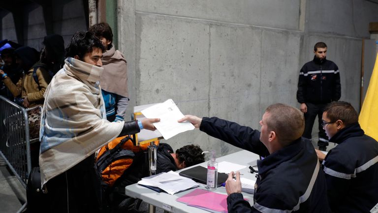 Migrants are processed to be evacuated to shelters across France