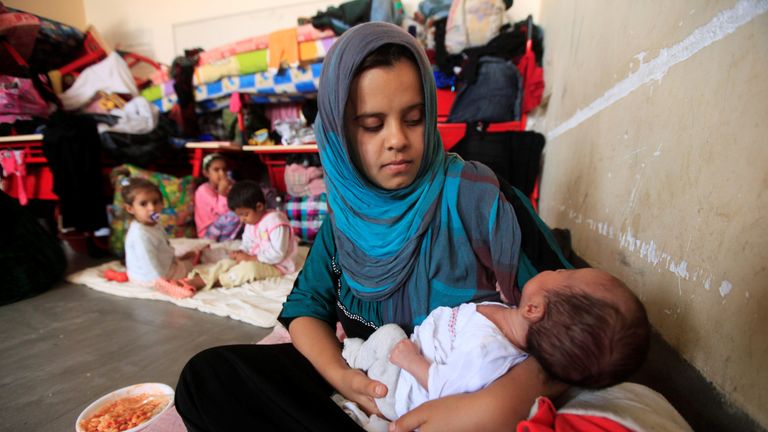 A displaced woman who fled from Islamic State militants in Mosul holds her baby at Deepaka camp in the northwest of Erbil