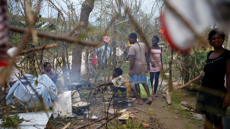 People cook next to fallen trees after Hurricane Matthew passes Jeremie, Haiti