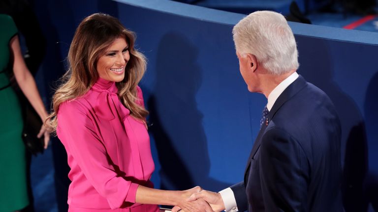 Melania Trump shakes hands with former US President Bill Clinton before the town hall debate at Washington University on October 9, 2016