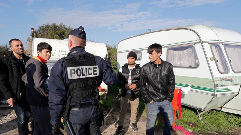 French police ask migrants to leave the area as the demolition of the camp starts
