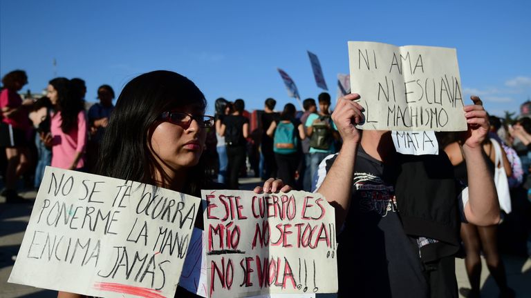 People hold banners during a march in Mexico City