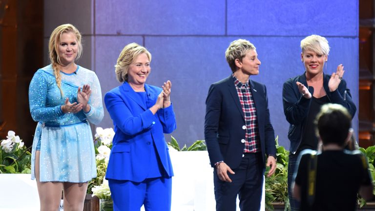 Hillary Clinton stands on stage with a number of female celebrities.