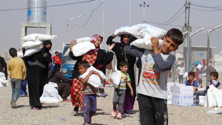 People who fled the Islamic State&#39;s strongholds of Hawija and Mosul, receive aid at a camp for displaced people in Daquq, Iraq