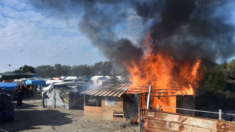 A shack is set on fire during the demolition