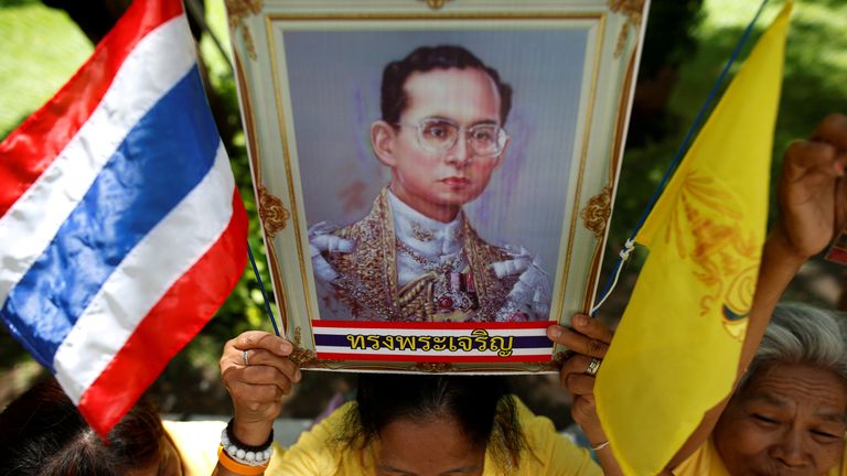 A well-wisher holds a picture of King Bhumibol Adulyadej at Siriraj hospital